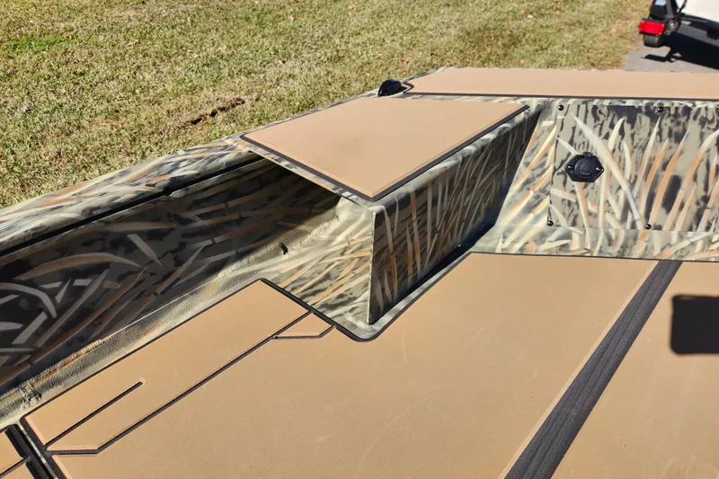 Slide: The Image of 2026 Tracker Grizzly 1756 T Marsh boat interior with camouflage design and storage compartment. - 13