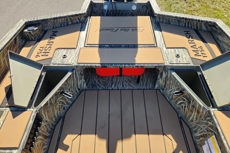 Slide: The Image of 2026 Tracker Grizzly 1756 T Marsh boat interior with storage compartments and camo design. - 16