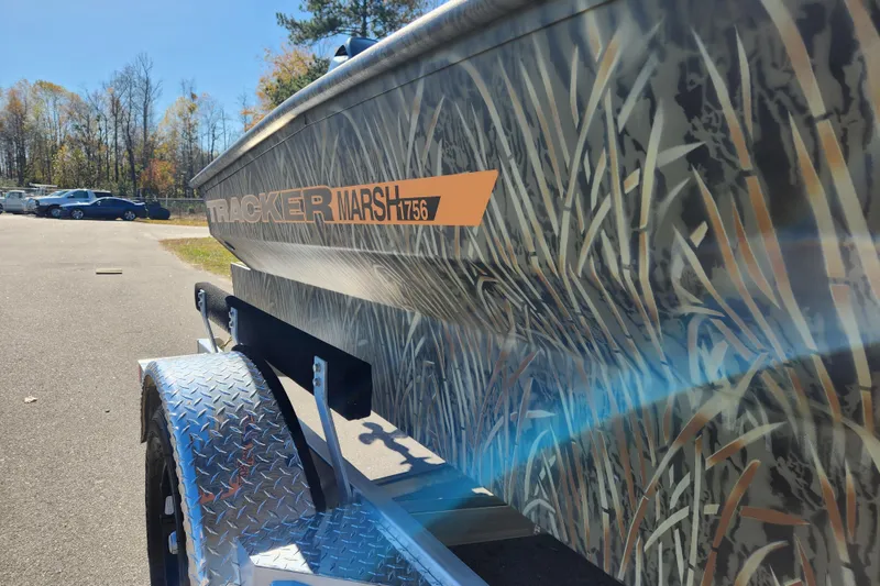 Slide: The Image of 2026 Tracker Grizzly 1756 T Marsh boat with camouflage design on a trailer. - 21