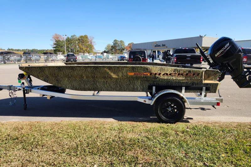 Slide: The Image of 2026 Tracker Grizzly 1756 T Marsh boat on trailer, camo design, parked outdoors. - 6