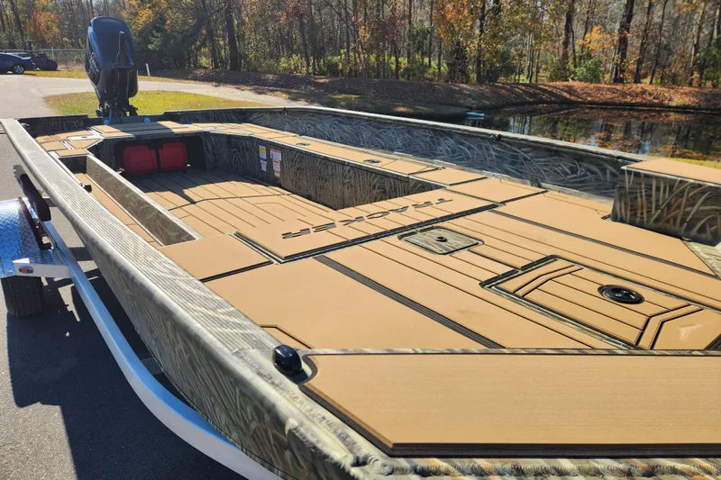 Slide: The Image of 2026 Tracker Grizzly 1756 T Marsh boat with camo design, parked outdoors. - 8