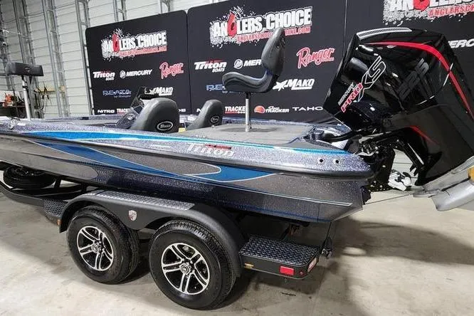 Slide: The Image of 2026 Triton 19 TrX Patriot bass boat on trailer in showroom setting. - 3