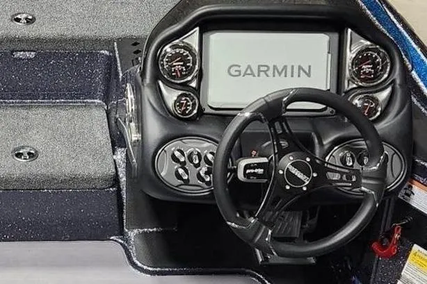 Slide: The Image of 2026 Triton 19 TrX Patriot boat dashboard with Garmin display and steering wheel. - 5