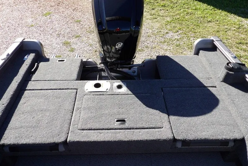 Slide: The Image of 2023 Lund 1675 Adventure SS boat interior with carpeted deck and motor. - 13