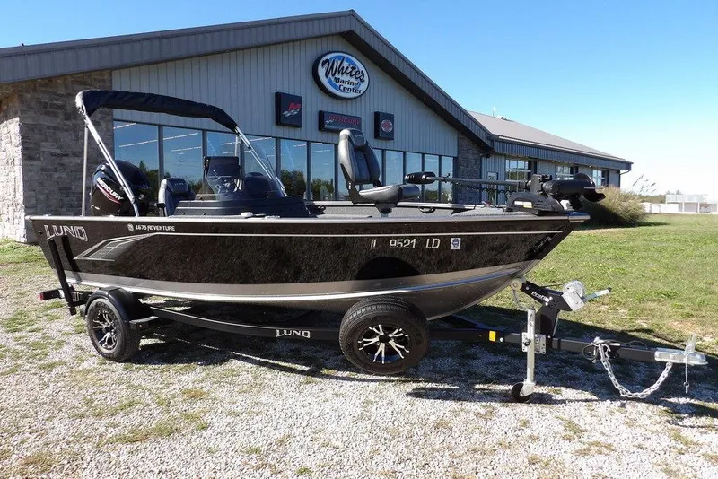 Slide: The Image of 2023 Lund 1675 Adventure SS boat on trailer outside marine center. - 3