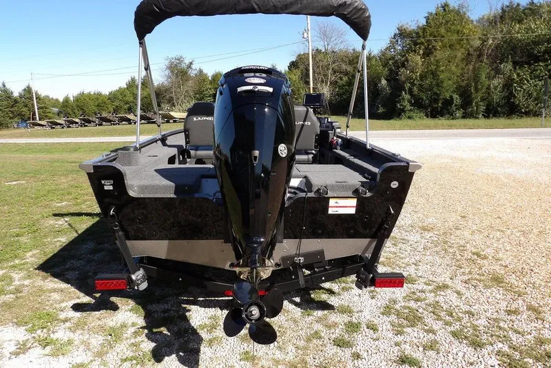 Slide: The Image of 2023 Lund 1675 Adventure SS boat with outboard motor, parked on gravel. - 6