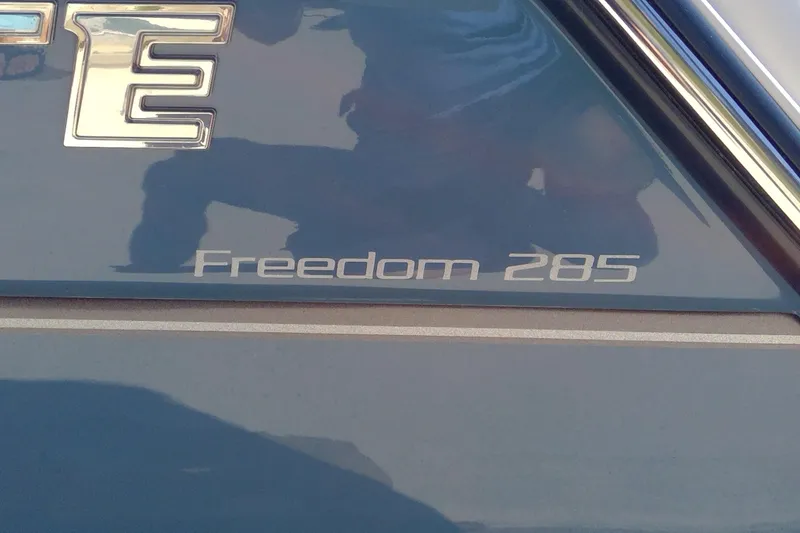 Slide: The Image of 2023 Grady-White Freedom 285 boat logo on blue surface. - 15