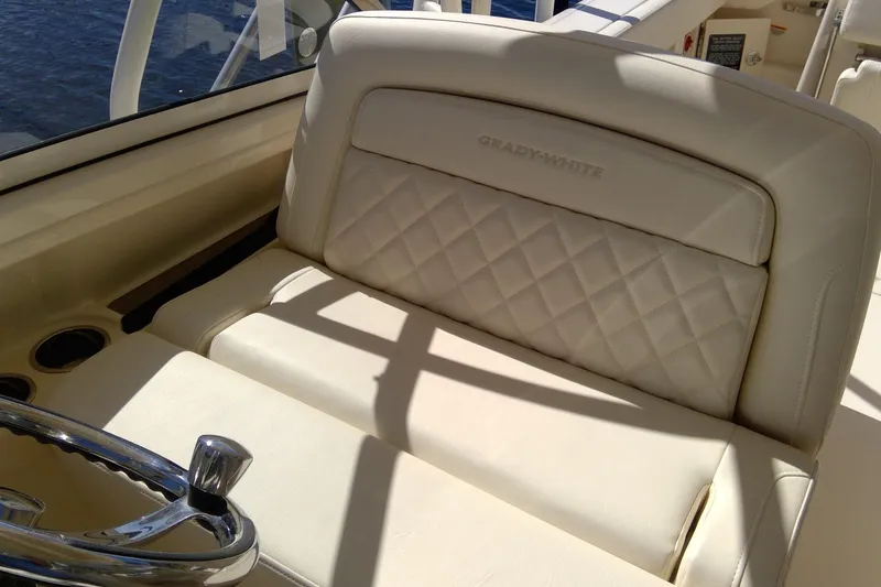 Slide: The Image of 2023 Grady-White Freedom 285 boat interior with luxurious seating and steering wheel. - 22