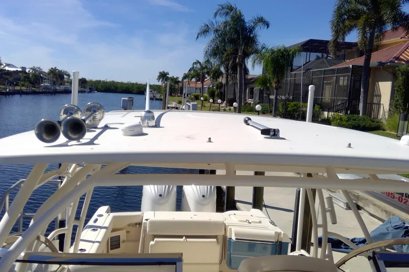 Slide: The Image of 2023 Grady-White Freedom 285 boat docked by a scenic waterfront with palm trees. - 37