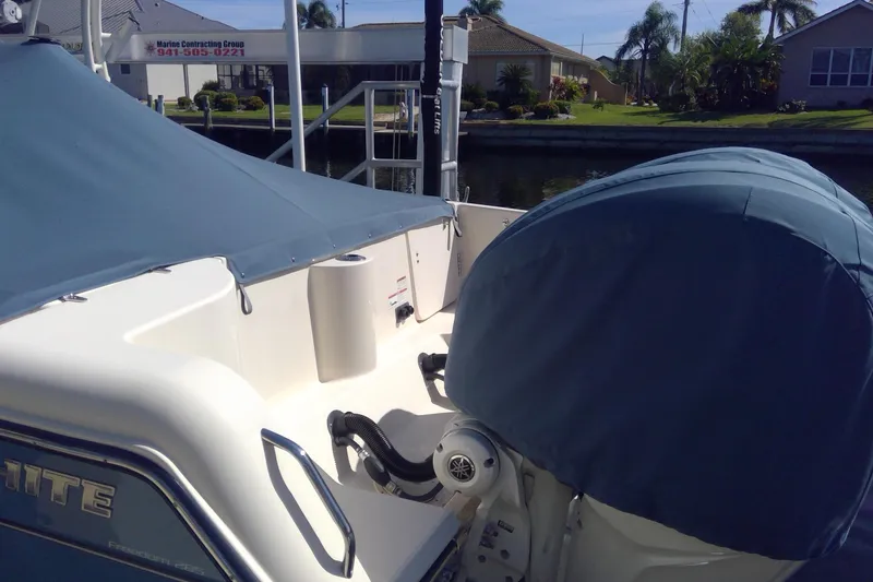 Slide: The Image of 2023 Grady-White Freedom 285 boat with covered seating and engine, docked near waterfront homes. - 51