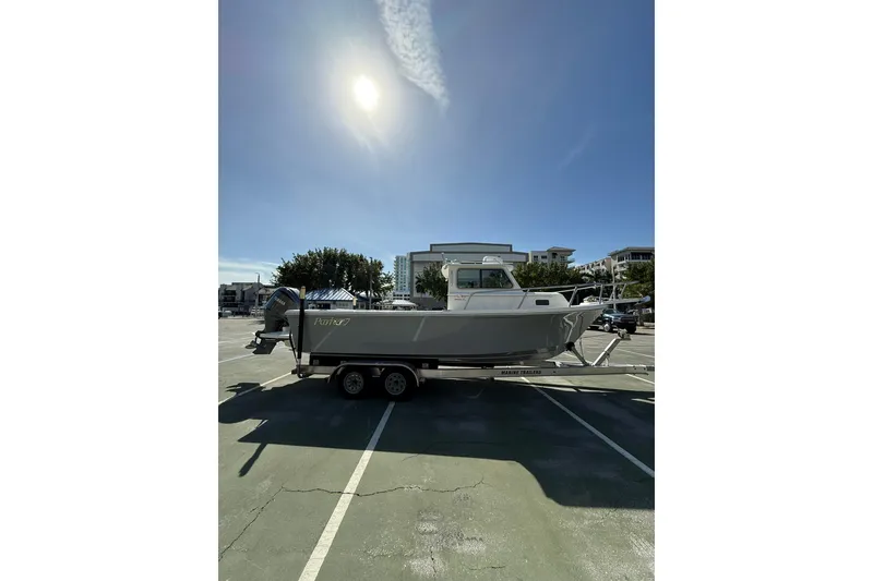 Slide: The Image of 2023 Parker 2320 Sport Cabin boat on trailer under sunny sky. - 20
