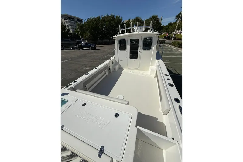 Slide: The Image of 2023 Parker 2320 Sport Cabin boat with spacious deck and cabin, parked outdoors. - 27