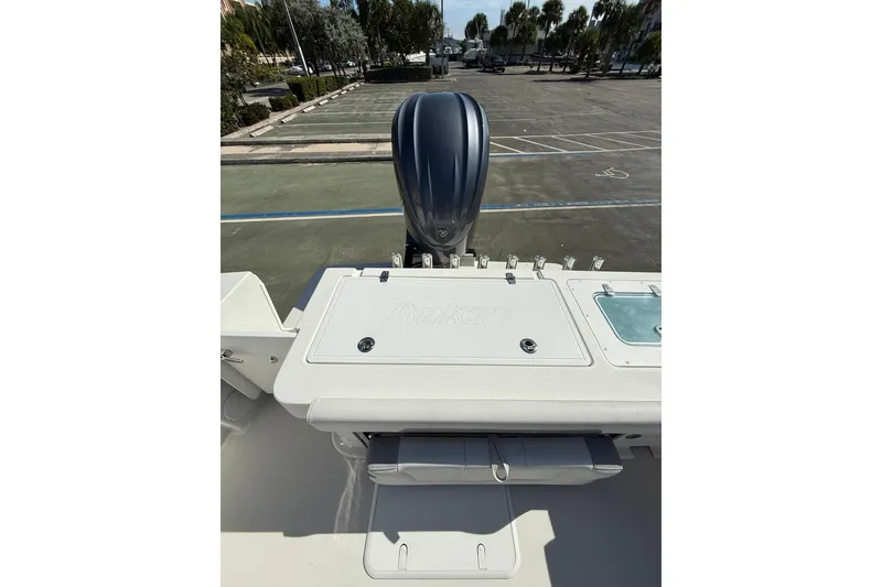 Slide: The Image of 2023 Parker 2320 Sport Cabin boat with outboard motor in parking lot. - 29