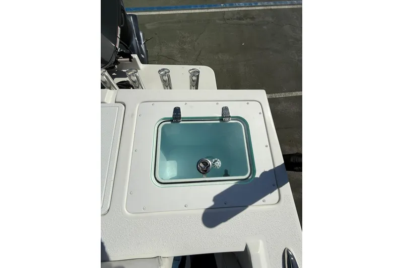 Slide: The Image of Livewell on 2023 Parker 2320 Sport Cabin boat, featuring rod holders and clean design. - 31