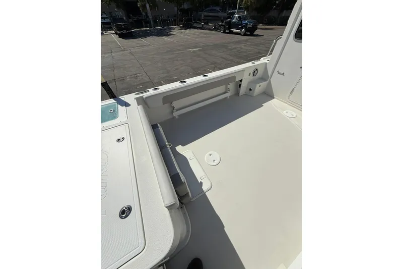 Slide: The Image of 2023 Parker 2320 Sport Cabin boat deck, spacious and clean, in a parking lot. - 33