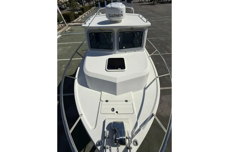 Slide: The Image of 2023 Parker 2320 Sport Cabin boat with Garmin radar, docked in a parking area. - 41