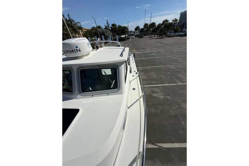 Slide: The Image of 2023 Parker 2320 Sport Cabin boat in a parking lot, featuring Garmin equipment. - 44