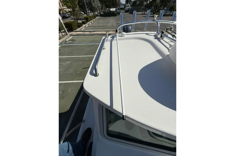 Slide: The Image of 2023 Parker 2320 Sport Cabin boat deck with railing, parked in a lot. - 46