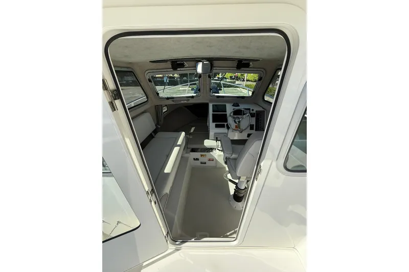 Slide: The Image of Interior view of 2023 Parker 2320 Sport Cabin boat, featuring helm and seating area. - 50