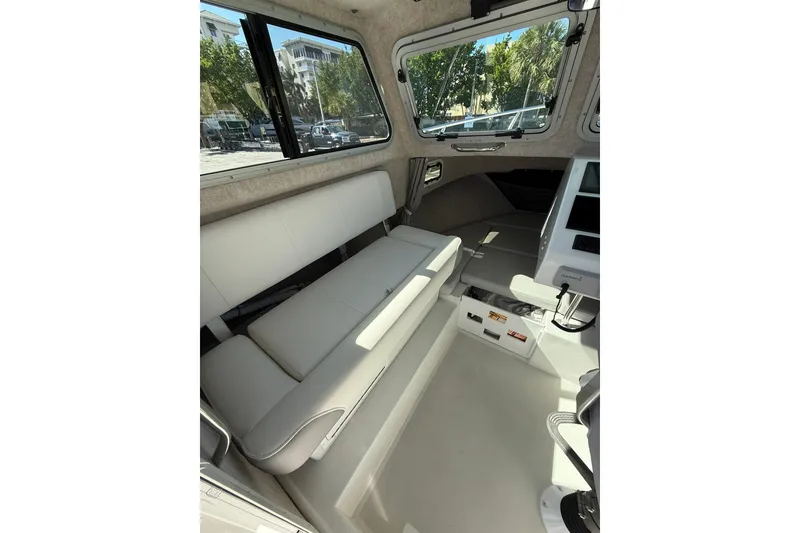 Slide: The Image of Interior of 2023 Parker 2320 Sport Cabin, featuring seating and navigation equipment. - 52