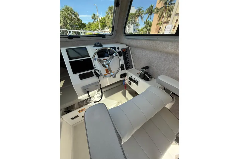 Slide: The Image of Interior of 2023 Parker 2320 Sport Cabin boat with steering wheel and controls. - 53