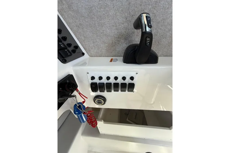 Slide: The Image of Control panel of 2023 Parker 2320 Sport Cabin boat with switches and throttle. - 62