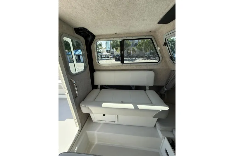 Slide: The Image of Interior of 2023 Parker 2320 Sport Cabin with white seating and windows. - 63