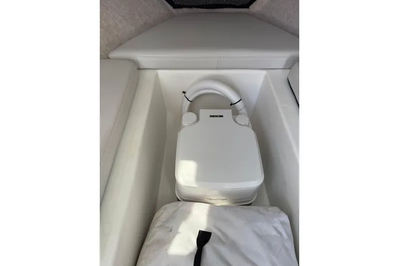Slide: The Image of 2023 Parker 2320 Sport Cabin interior with portable toilet and white seating. - 68