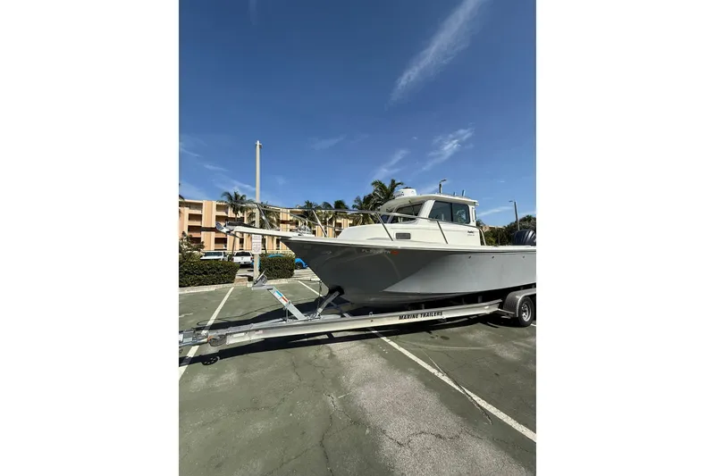 Slide: The Image of 2023 Parker 2320 Sport Cabin boat on trailer in parking lot. - 7