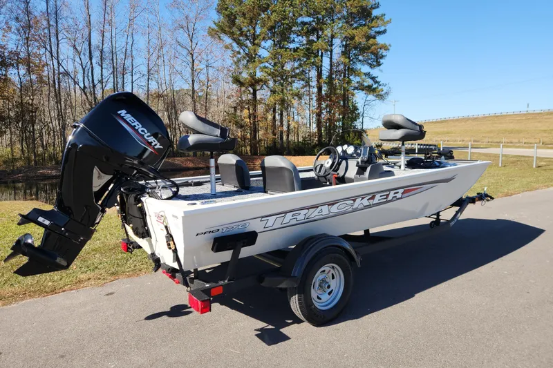 Slide: The Image of 2026 Tracker Pro 170 boat with Mercury engine on a trailer, parked outdoors. - 2