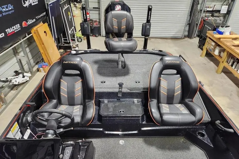 Slide: The Image of 2019 Nitro Z20 Pro boat interior with three black and orange seats in a garage setting. - 11