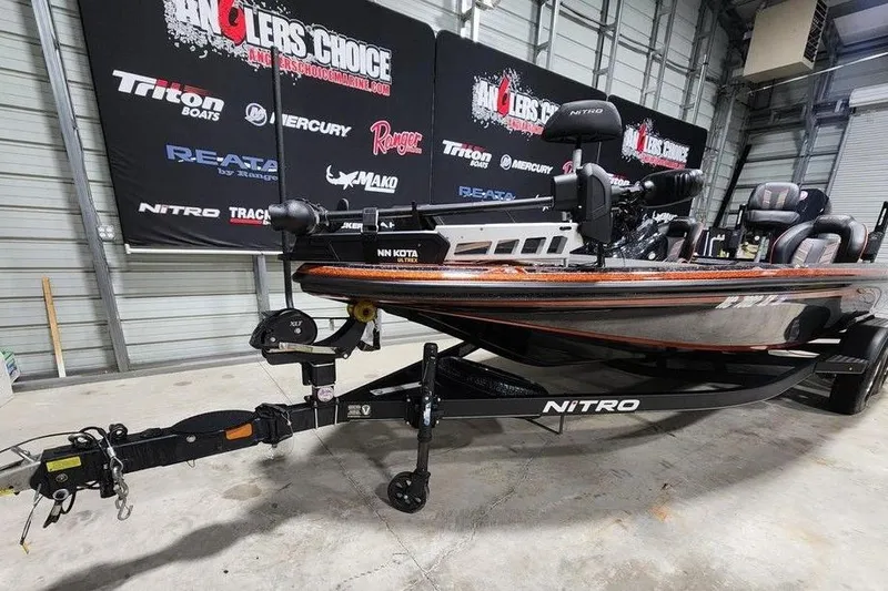 Slide: The Image of 2019 Nitro Z20 Pro fishing boat on trailer in showroom with promotional banners. - 4