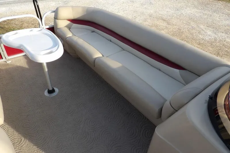 Slide: The Image of 2012 Sun Tracker Party Barge 22 DLX interior with beige seating and a white table. - 17