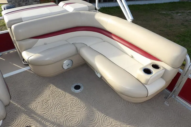 Slide: The Image of 2012 Sun Tracker Party Barge 22 DLX interior with beige and red seating, cup holders. - 30