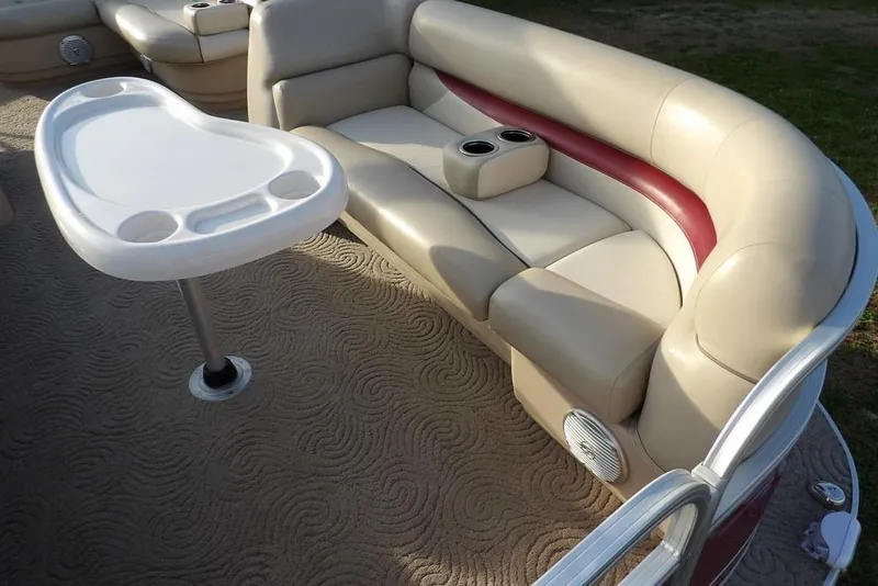 Slide: The Image of 2012 Sun Tracker Party Barge 22 DLX interior with beige seating and table. - 9