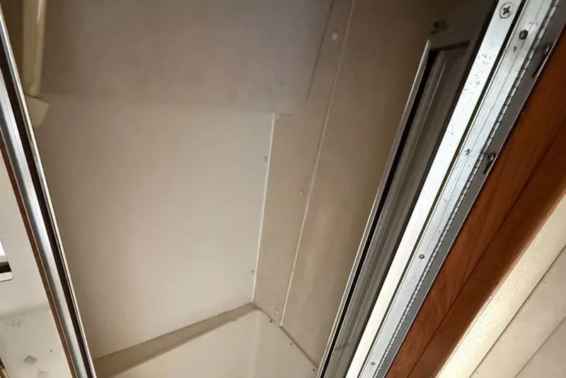 Slide: The Image of Interior view of a 1990 Silverton 34 Convertible boat, featuring a ceiling and wooden trim. - 11