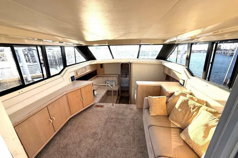Slide: The Image of Interior of a 1990 Silverton 34 Convertible yacht with cozy seating and panoramic windows. - 13