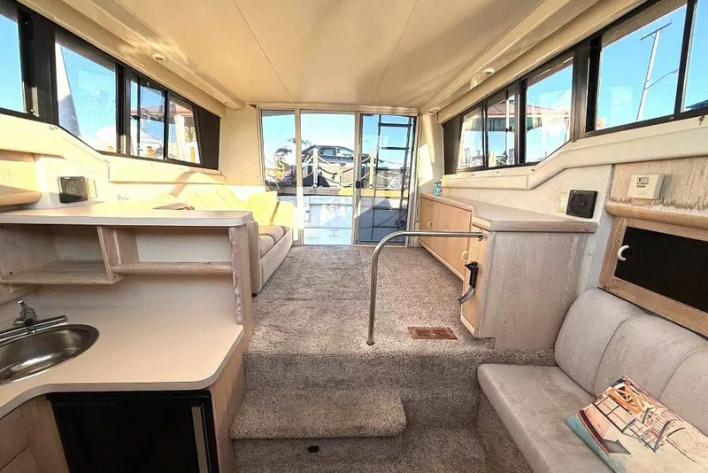 Slide: The Image of Interior of a 1990 Silverton 34 Convertible yacht, featuring a cozy cabin layout. - 14