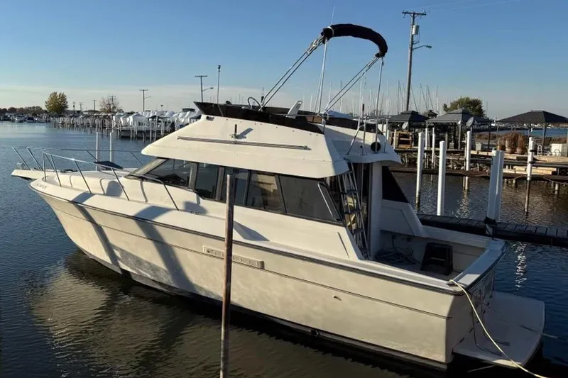 Slide: The Image of 1990 Silverton 34 Convertible boat docked in a marina under clear skies. - 16