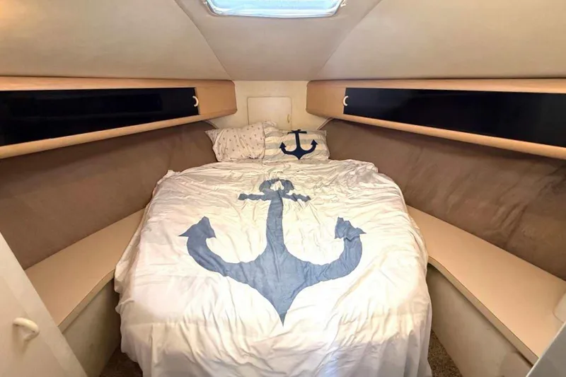 Slide: The Image of 1990 Silverton 34 Convertible cabin with anchor-themed bedding and cozy interior. - 18