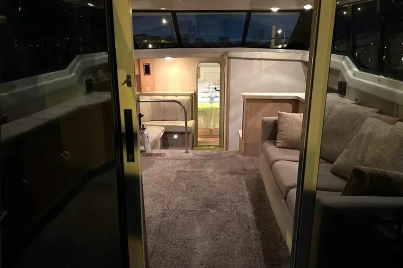 Slide: The Image of Interior of 1990 Silverton 34 Convertible yacht with cozy seating and carpeted flooring. - 2