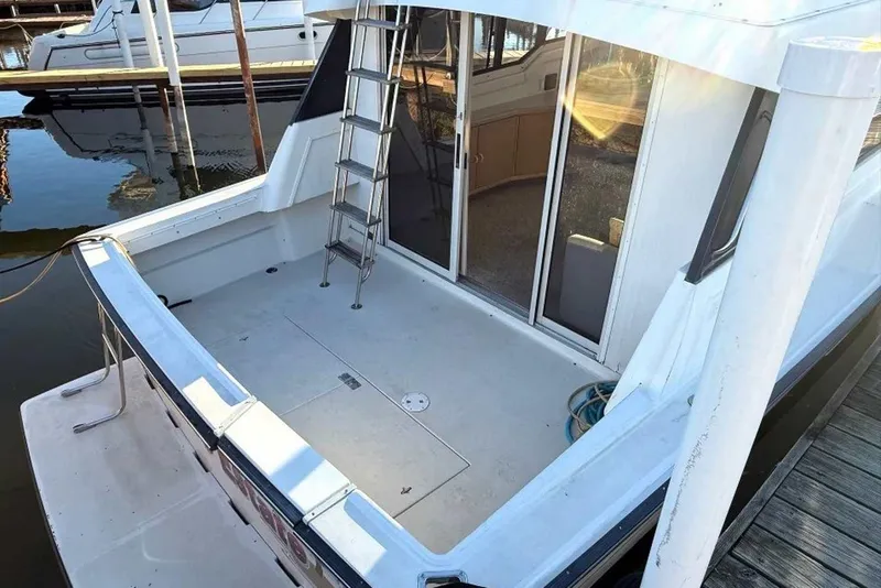 Slide: The Image of 1990 Silverton 34 Convertible boat with spacious deck and ladder, docked at marina. - 20