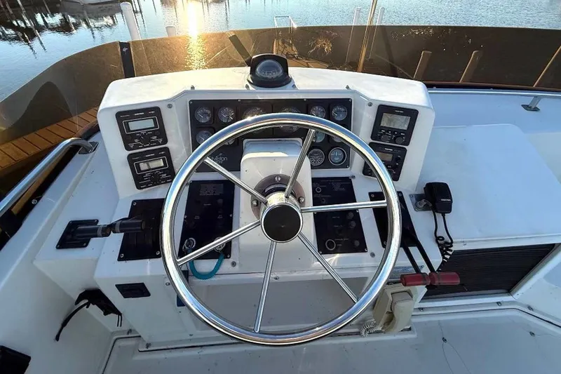 Slide: The Image of 1990 Silverton 34 Convertible boat helm with steering wheel and control panel. - 21