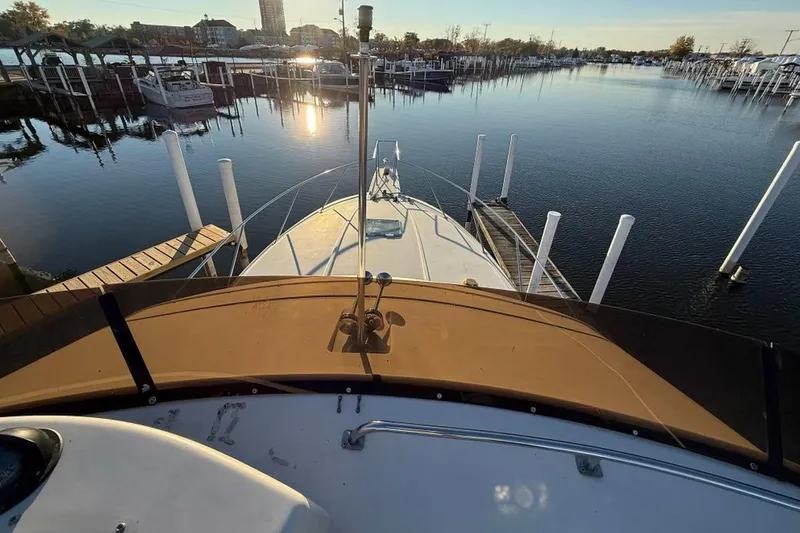 Slide: The Image of 1990 Silverton 34 Convertible yacht docked at a serene marina during sunset. - 23