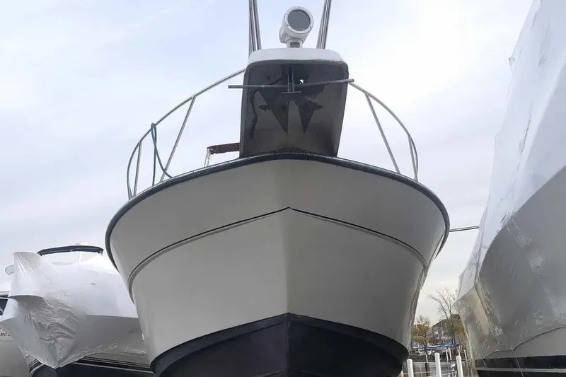 Slide: The Image of 1990 Silverton 34 Convertible boat, docked, front view, with overcast sky. - 28