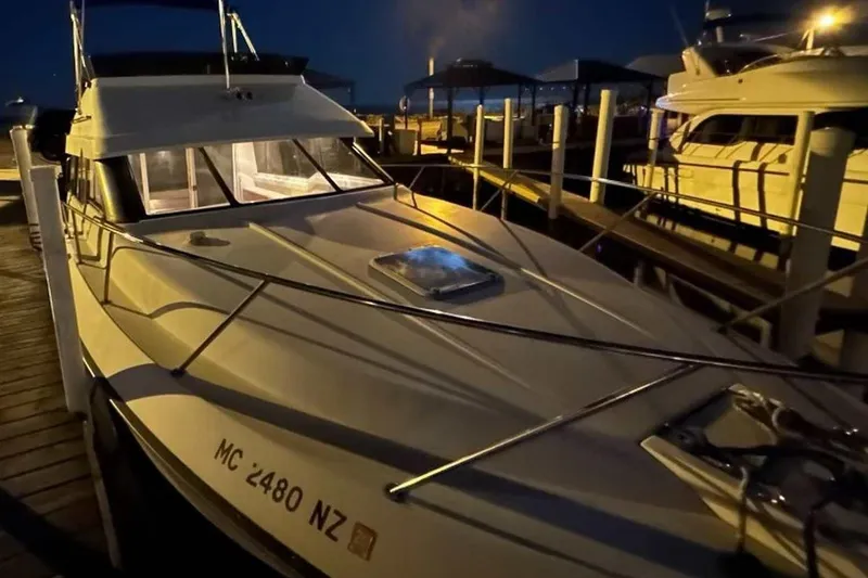 Slide: The Image of 1990 Silverton 34 Convertible docked at night, illuminated by soft lighting. - 34