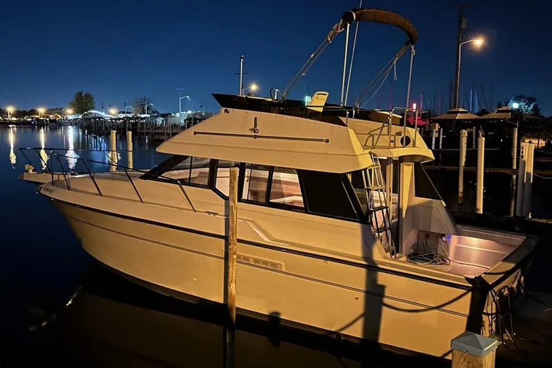 Slide: The Image of 1990 Silverton 34 Convertible boat docked at night, illuminated by marina lights. - 35