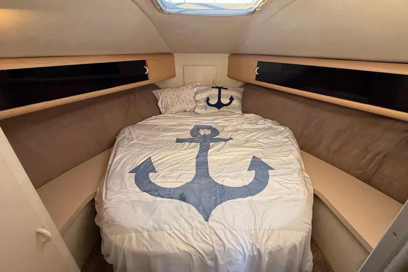 Slide: The Image of Cozy cabin interior of 1990 Silverton 34 Convertible with anchor-themed bedding. - 8