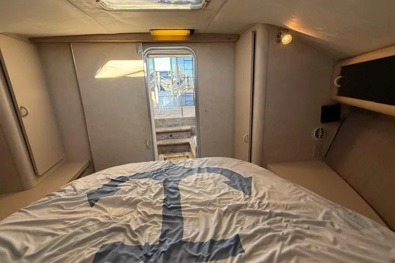 Slide: The Image of Interior cabin of 1990 Silverton 34 Convertible yacht with bed and natural light. - 9