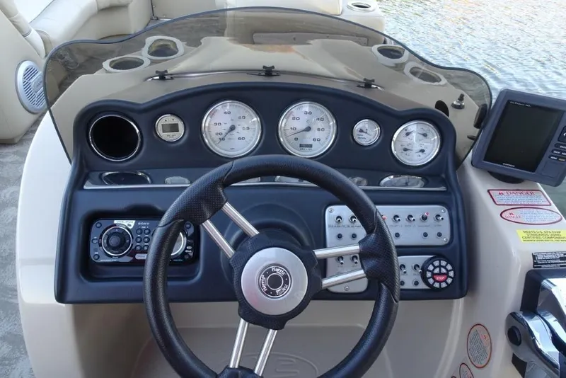 Slide: The Image of Dashboard of a 2010 Harris Grand Mariner 230 boat with steering wheel and gauges. - 16